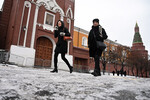 Женщины идут по Красной площади во время ледяного дождя в Москве, 22 ноября 2022 года