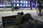 Бездомный житель города читает книгу на скамейке на Страстном бульваре 