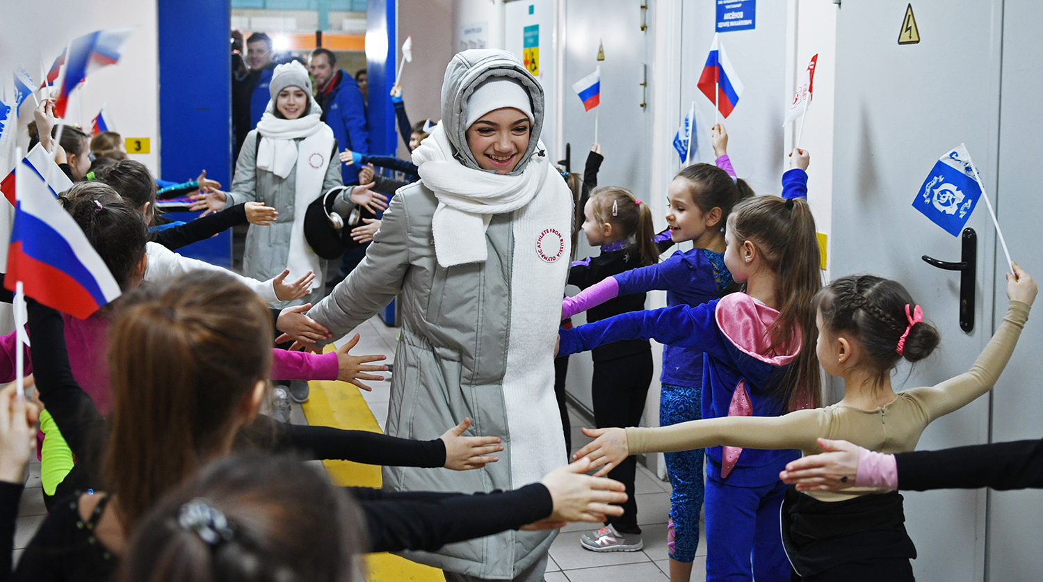 Фигуристки Алина Загитова и Евгения Медведева (в центре слева направо) во время торжественных проводов на Олимпиаду