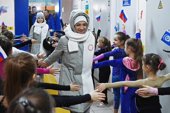 Фигуристки Алина Загитова и Евгения Медведева (в центре слева направо) во время торжественных проводов на Олимпиаду