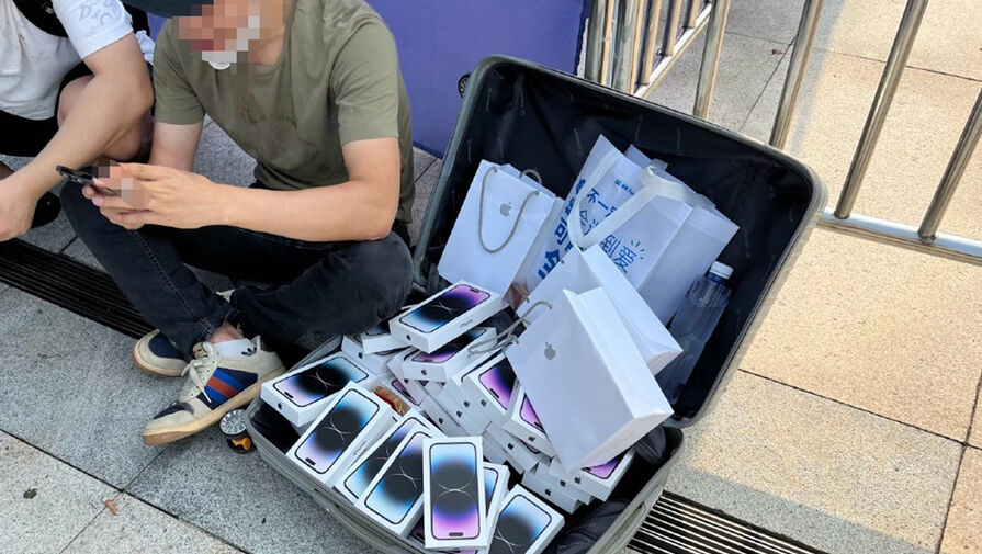 В Китае сфотографировали перекупщика с полным чемоданом iPhone 14