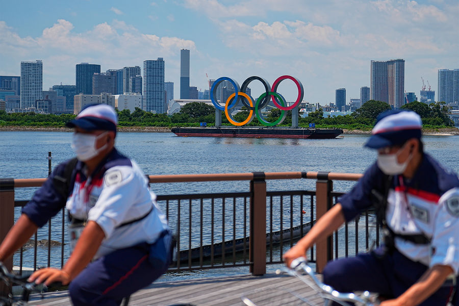 Сотрудники безопасности на&nbsp;фоне понтона с&nbsp;олимпийскими кольцами в&nbsp;Токийском заливе, 20 июля 2021 года