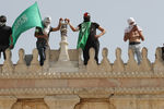 Жители Палестины держат флаг ХАМАС в районе мечети «Аль-Акса» на Храмовой горе в Иерусалиме, 10 мая 2021 года
