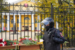 Полицейский возле мемориала в память о погибших во время стрельбы в Пермском государственном национальном исследовательском университете перед входом в университет, Пермь, 21 сентября 2021 года