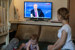 Мама с ребенком смотрит трансляцию «Прямой линии с Владимиром Путиным» в Омске