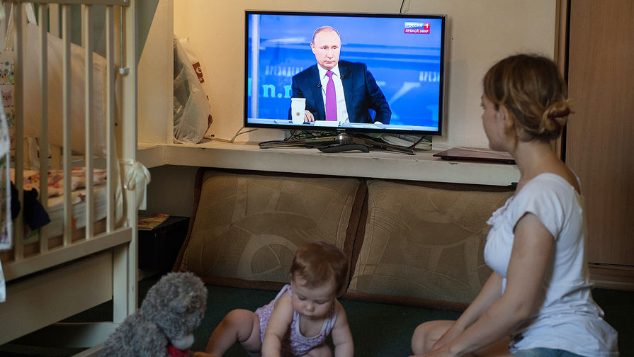Мама с ребенком смотрит трансляцию «Прямой линии с Владимиром Путиным» в Омске