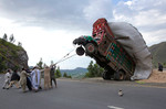 13 апреля. Люди пытаются поставить на колеса грузовик, «вставший на попа» из-за перегруженности соломой на дороге в Даргай, Пакистан.