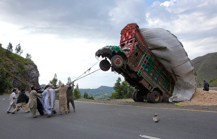 13&nbsp;апреля. Люди пытаются поставить на&nbsp;колеса грузовик, &laquo;вставший на&nbsp;попа&raquo; из-за перегруженности соломой на&nbsp;дороге в&nbsp;Даргай, Пакистан.