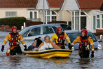 Спасатели помогают жителям Уэльса, на одной из затопленных в результате шторма улиц города.