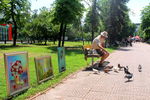 Художник кормит голубей в центре Луганска