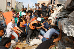 Палестинцы ищут пострадавших под обломками дома, разрушенного в результате удара Израиля на юге сектора Газа, 8 октября 2023 года