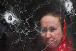 Женщина за стеклом трапезной Александро-Невского храма, поврежденного в результате обстрела в ДНР, 28 апреля 2024 года