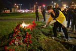 Молодой человек возлагает цветы у здания «Вагнер-центра» в Санкт-Петербурге, 24 августа 2023 года