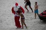 Мальчик и пожарный в костюме Санта-Клауса на пляже Копакабана, Рио-де-Жанейро, 4 декабря 2025 года