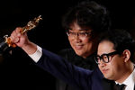 Пон Чжун Хо и Хан Джин-вон со статуэтками за лучший оригинальный сценарий в фильме «Паразиты» во время церемонии вручения кинопремии «Оскар» в Лос-Анджелесе, 9 февраля 2020 года
