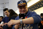 Покупатель примеряет часы Apple Watch в магазине в Пекине