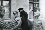 Освобожденный русский узник лагеря Бухенвальд указывает на тюремщика, избивавшего заключенных, 14 апреля 1945 года