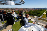 Участники так называемого «ужина в небе» возле базилики Кекельберг в Брюсселе (люди сидят на конструкции, подвешенной к крану на высоте пятидесяти метров), 14 июня 2022 года