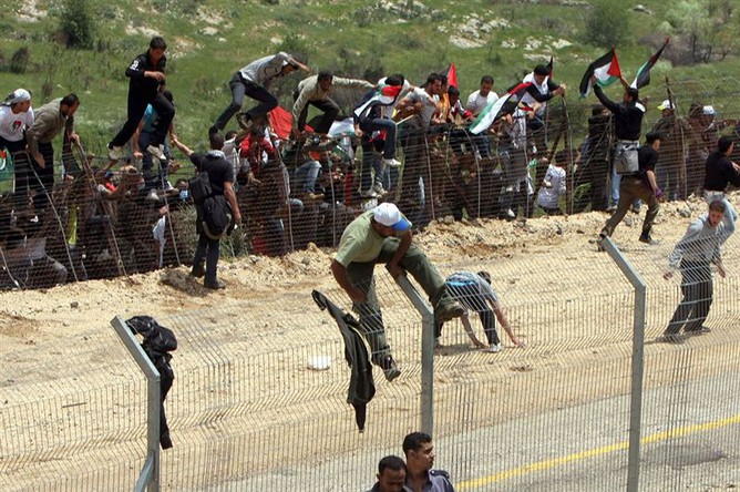Палестинцы пытаются перебраться через стену на границе с Израилем со стороны Сирии