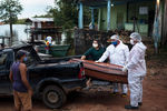 Сотрудники ритуальной службы загружают гроб с телом умершего от коронавируса в городе Манаус, Бразилия