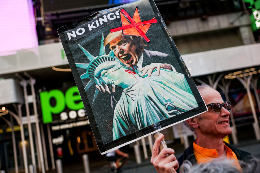Мужчина держит плакат с&nbsp;изображением президента США Дональда Трампа в&nbsp;образе вампира во время акции протеста «No Kings» против политики Трампа, Нью-Йорк, 18&nbsp;октября 2025&nbsp;года