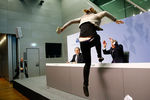 Участница акции протеста запрыгивает на стол перед президентом Европейского центрального банка Марио Драги во время пресс-конференции во Франкфурте