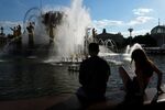 Отдыхающие у фонтана «Дружба народов» на ВДНХ в Москве, 26 июня 2022 года