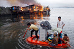 11 мая. Местные жители спасаются от пожара, охватившего по меньшей мере тысячу домов в трущобах Манилы.