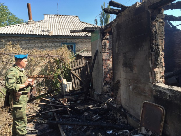 Ополченец осматривает дом, пострадавший в&nbsp;результате обстрела украинскими силовиками города Горловки Донецкой области