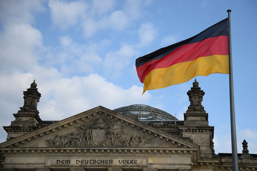 Национальный флаг Федеративной Республики Германии над зданием Будестага в Берлине