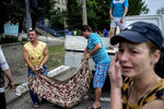 Жители Луганска складывают тела погибших в результате артиллерийского обстрела города