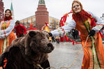 Участницы анимационной программы, одетые в праздничные костюмы, с актером в костюме медведя во время открытия фестиваля «Московская Масленица» на Манежной площади