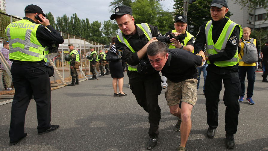 Сотрудники правоохранительных органов арестовывают мужчину во время акции «Бессмертный полк» в Киеве, 9 мая 2018 года