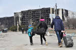 People with suitcases walking towards the exit from Mariupol, March 2022