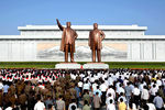 Жители КНДР возле памятников Ким Ир Сену и его сыну Ким Чен Иру в годовщину смерти «Великого вождя»