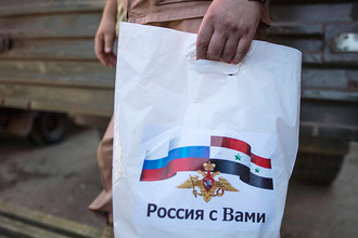 Сотрудник Координационного центра по примирению враждующих сторон в Сирии во время раздачи гуманитарной помощи от России в лагере внутренне перемещенных лиц в бывшей гостинице вагоностроительного завода у города Хама