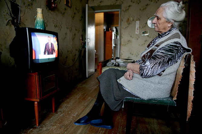  Женщина смотрит телетрансляцию послания президента России Владимира Путина Федеральному Собранию РФ