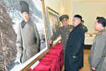 Ким Чен Ын в музее возле картины с Ким Ир Сеном, 2013 год 