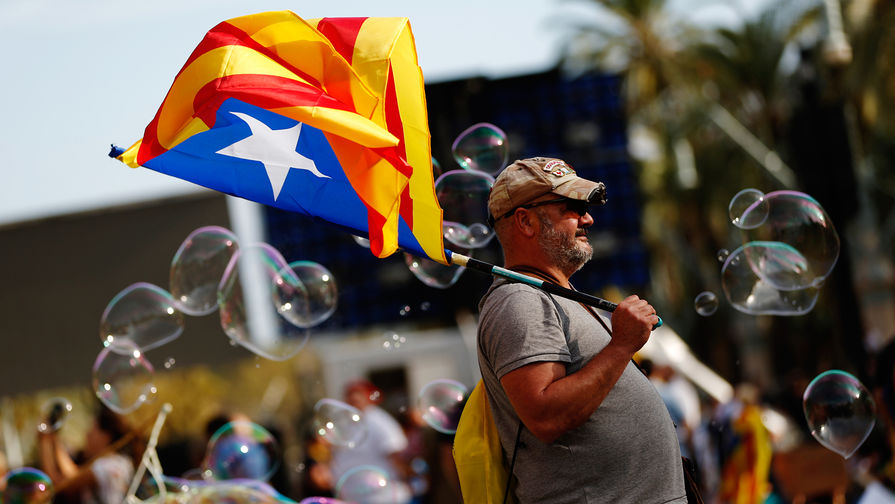Мужчина с флагом Каталонии во время митинга в Барселоне, 10 октября 2017 года