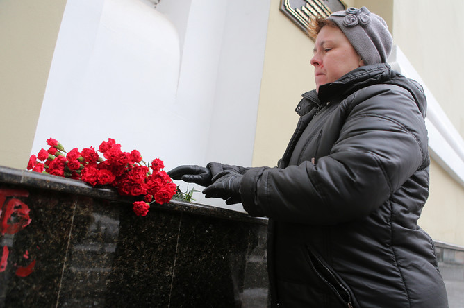 Женщина возлагает цветы к зданию Академического ансамбля песни и пляски Российской армии им. А.В. Александрова в Москве. Самолет Минобороны РФ Ту-154, на борту которого находились артисты ансамбля, потерпел крушение у побережья Черного моря в Сочи