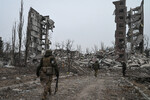 Военнослужащие у разрушенного в ходе боев здания квартала Юбилейный в Авдеевке, февраль 2024 года