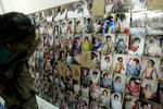 Женщина смотрит на фотографии погибших в результате цунами в городе Нагапаттинам, Индия