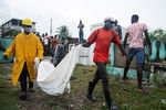 Местные жители выносят тело погибшего от землетрясения, Ле-Кей, Гаити, 17 августа 2021 года