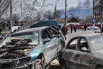 Residents and broken cars on Mariupol street, March 2022