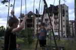 Дети играют во дворе разрушенного дома в Ирпене, 12 июня 2022 года