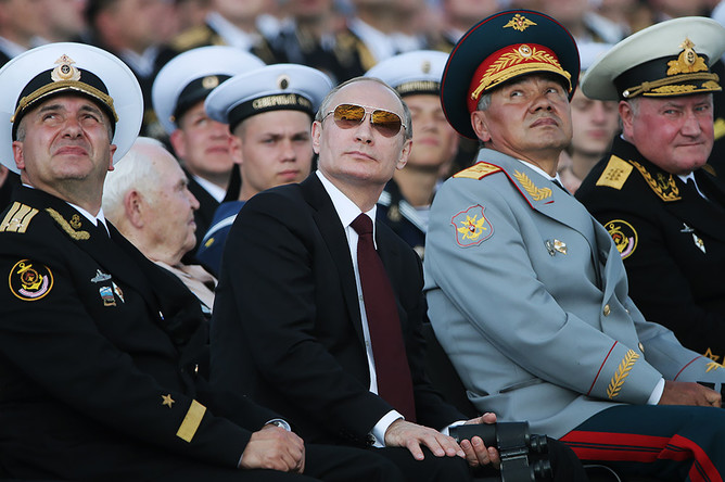 Президент РФ Владимир Путин (в центре) и министр обороны РФ Сергей Шойгу (второй справа) на военно-морском параде в День ВМФ России в Североморске