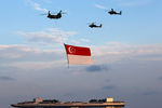 Вертолеты ВВС Сингапура пролетают с национальным флагом над заливом Марина-Бэй в честь 50-летней годовщины независимости Сингапура
