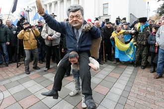 Участник протестного митинга перед зданием Верховной рады в центре Киева в маске президента Украины Петра Порошенко, 22 октября 2017 года