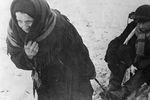 Ленинград в дни блокады. Женщина везет ослабевшего от голода мужа на санках