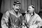 Иосиф Сталин и Климент Ворошилов в национальных костюмах от делегатов — участников совещания передовых колхозников Туркмении и Таджикистана, 1935 год